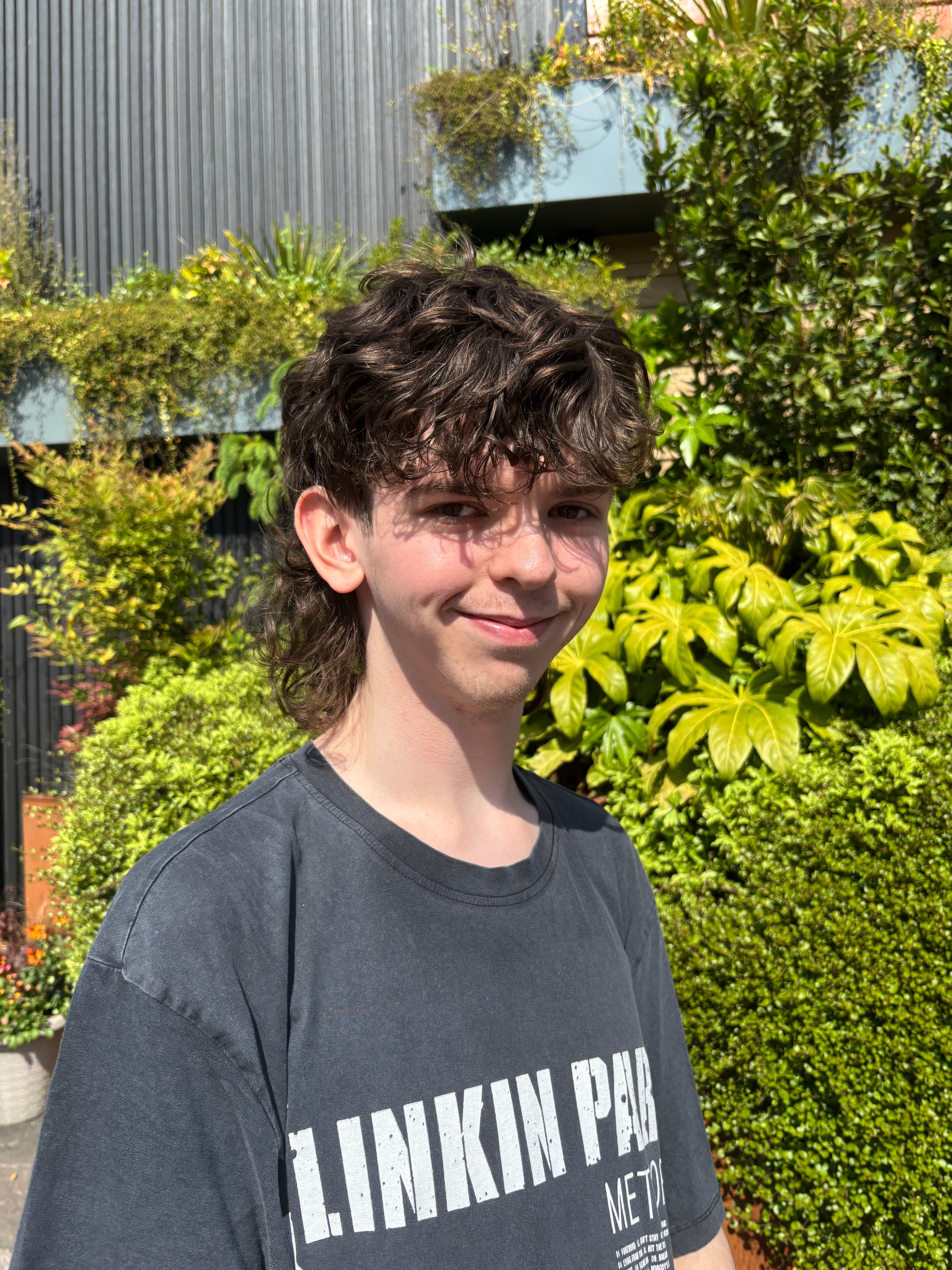 Image of Kieran stood in front of some greenery